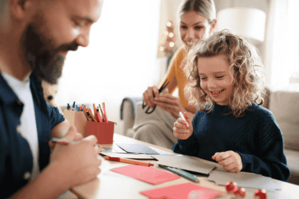 Family crafting holiday cards together happily.d