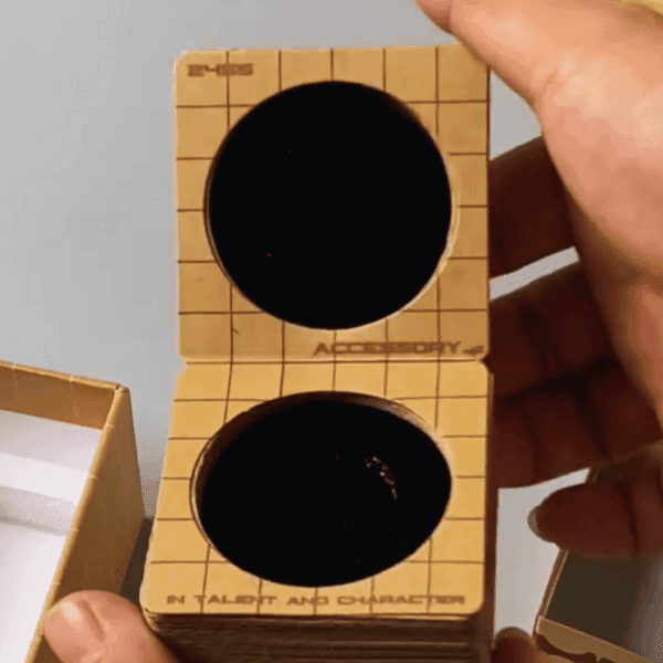 Hand holding an open honeycomb cardboard box with circular cutouts, designed for eco-friendly packaging.