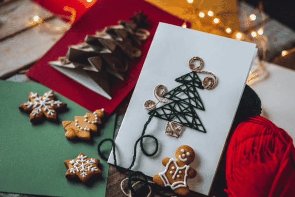 Handmade Christmas card with festive decorations and cookies.