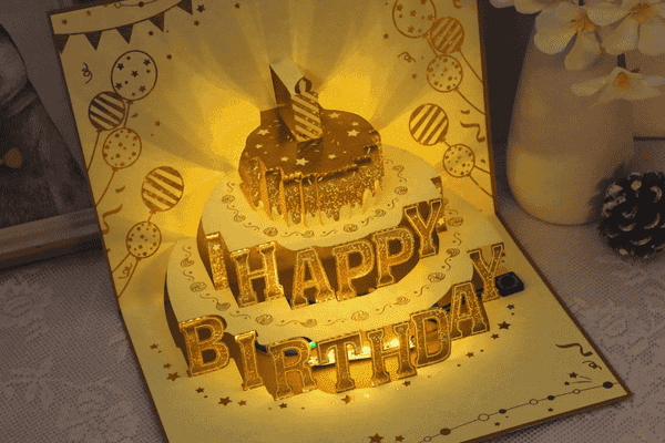Illuminated pop-up birthday card with cake design.