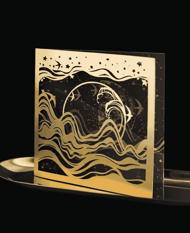 Luxurious gold and black laser-cut greeting card with an artistic wave and moon design.