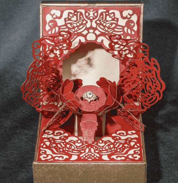 Luxurious red pop-up gift box with intricate design.