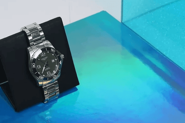Luxury silver watch on reflective display.