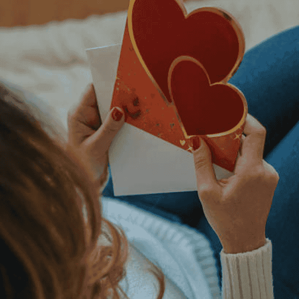 Person holding a handmade heart-shaped greeting card.