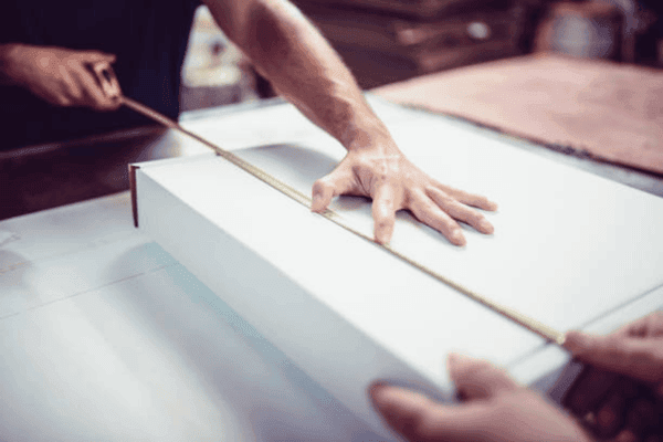 Quality control team measuring box dimensions with caliper