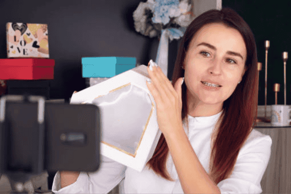 Influencer recording luxury perfume unboxing on phone