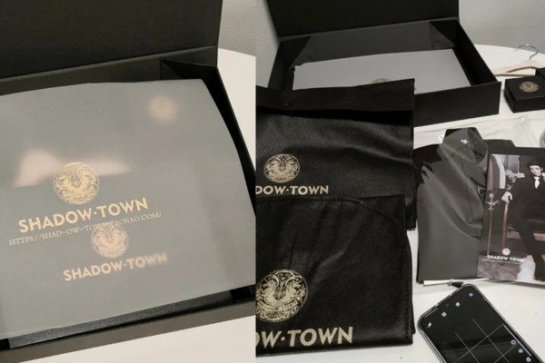 Black magnetic rigid apparel box with folded sweater and brand logo