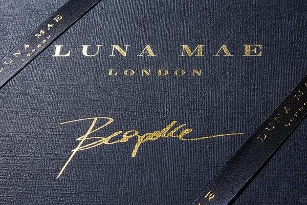 Close-up of apparel box materials with foil logo, textured paper, and tissue paper