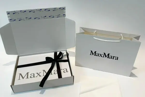 Foldable rigid apparel box shown flat and assembled with clothing inside