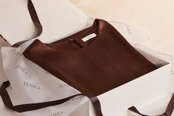 Premium custom apparel packaging with folded clothing and tissue paper