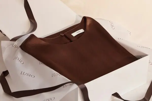 Premium custom apparel packaging with folded clothing and tissue paper